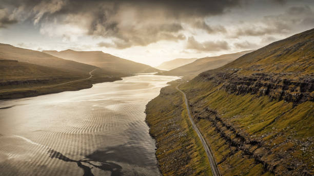 Faroe Islands Coastal Fjord Road between Streymoy and Eysturoy Island Sunset Panorama Moody Sunset Panorama Coastal Fjord Road between Streymoy Island and Eysturoy Island of the Faroe Islands. Aerial Drone Point of view Panorama over the North Atlantic Ocean Fjord Canal. Streymoy Island - Eysturoy Island, Haldarsvík, Faroe Islands, Kingdom of Denmark, Nordic Counties, Europe eysturoy stock pictures, royalty-free photos & images