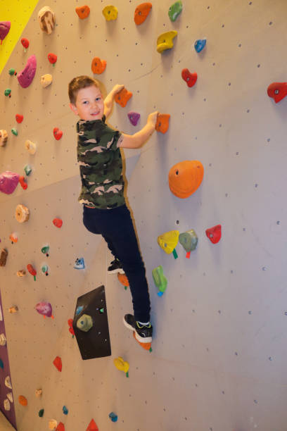 istock Young boy climbing on bouldering wall 1302053669