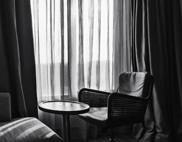 Black and white picture with chair and table.