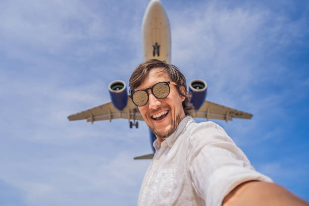 istock A man takes a selfie against the sky and a flying plane 1302059854