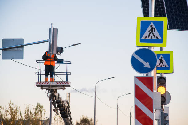 worker on the lift sets and adjusts the traffic light at the pedestrian crossing - 13520 imagens e fotografias de stock