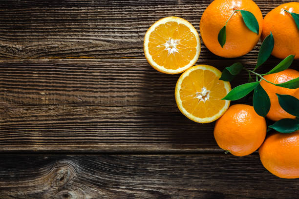 istock Fresh orange fruit, from above on wooden background 1302062399