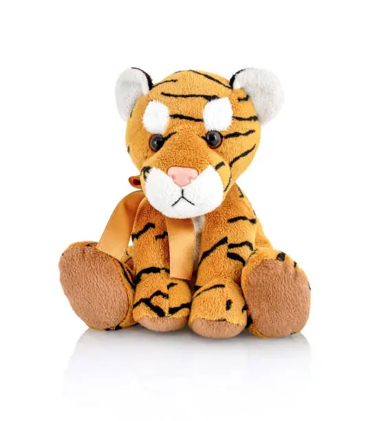 Tiger plushie doll isolated on white background with shadow reflection. Playful bright brown puppy toy. Plush stuffed puppet on white backdrop. Fluffy toy for children. Cute furry plaything for kids.