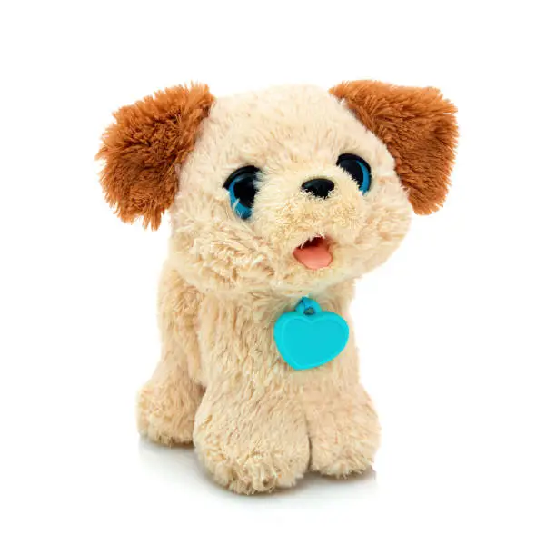 Photo of Dog plushie doll isolated on white background with shadow reflection. Playful bright brown puppy toy. Plush stuffed puppet on white backdrop. Fluffy toy for children. Cute furry plaything for kids.