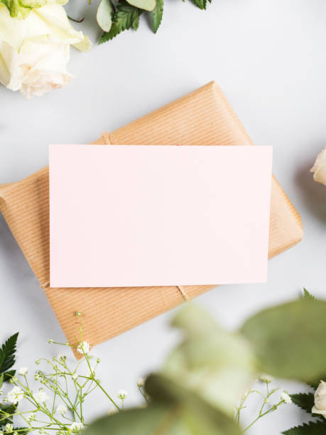 istock Wrapped craft gift box with blank pink card and flowers around 1302065695