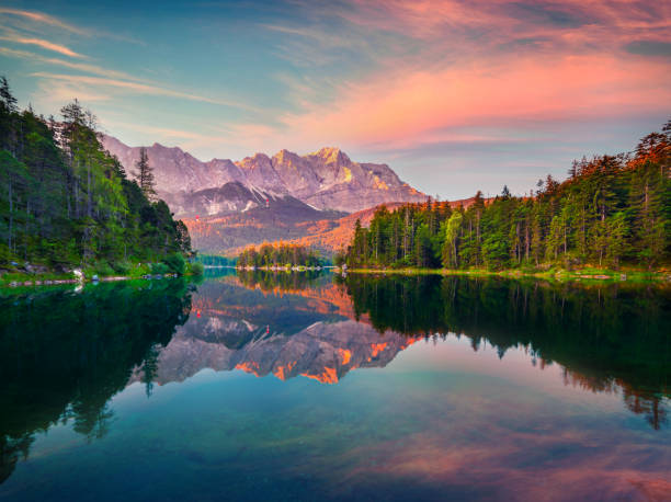 imponujący letni wschód słońca nad jeziorem eibsee z pasmem górskim zugspitze. wspaniała scena plenerowa w niemieckich alpach, bawarii, lokalizacji miejscowości garmisch-partenkirchen, niemcy, europa. - zugspitze mountain bavaria mountain germany zdjęcia i obrazy z banku zdjęć