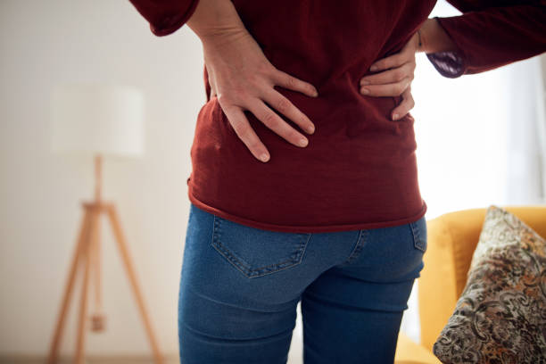 istock Woman with back / hip pain at home. 1302070989