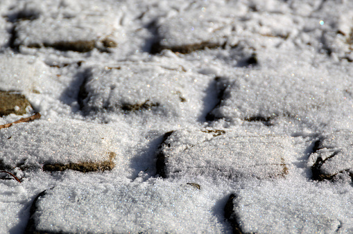 Old Cobblestones covered with snow close up.