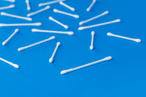 istock Cotton ear stick macro view, isolated on blue 1302076962