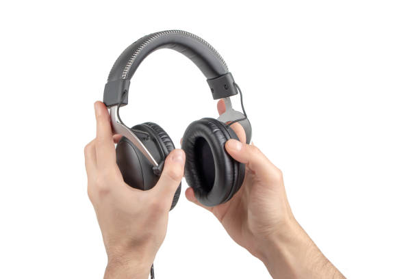 istock Hands Holding Headphones on White Background 1302077066