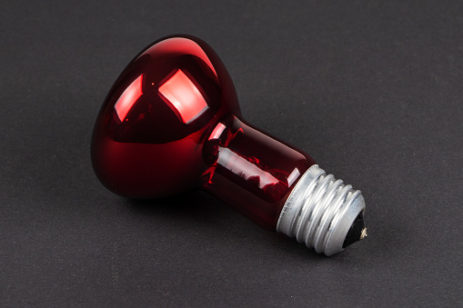 Incubator red lamp on dark background.