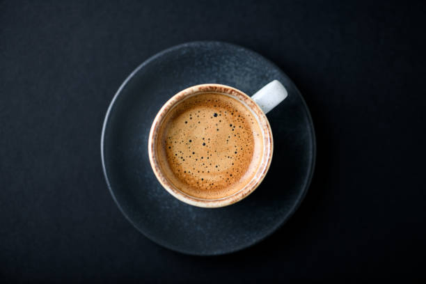 istock Cup of coffee on black background. Top view. Copy space. 1302078180