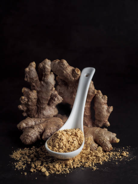 Ginger root and ginger powder in a spoon, close-up. stock photo