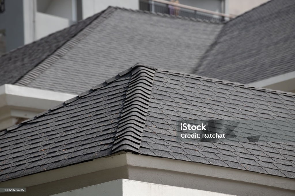 roof shingle background and texture. dark asphalt tiles on the roof. Rooftop Stock Photo