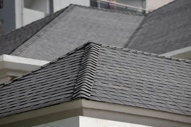 Photo of roof shingle background and texture. dark asphalt tiles on the roof.