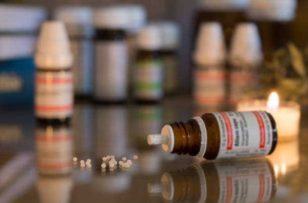 istock Homeopathy globules and vials on a table with old books 1302082241