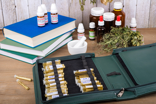 Homeopathy globules and vials on a table with old books