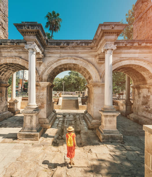 幸せな女性観光客旅行者は、トルコのアンタルヤの旧市街で興味深い場所や人気観光スポットや散歩を発見します。ハドリアヌスの有名なローマ門 - エフェソス ストックフォトと画像
