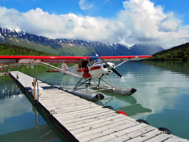 Seaplane Cessna float plane sits at dock in early morning light. bush plane stock pictures, royalty-free photos & images