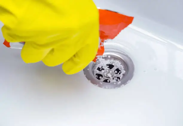 The drain cleaner granules in sink. Cleaning the plughole of a bathroom sink to unblock the drain