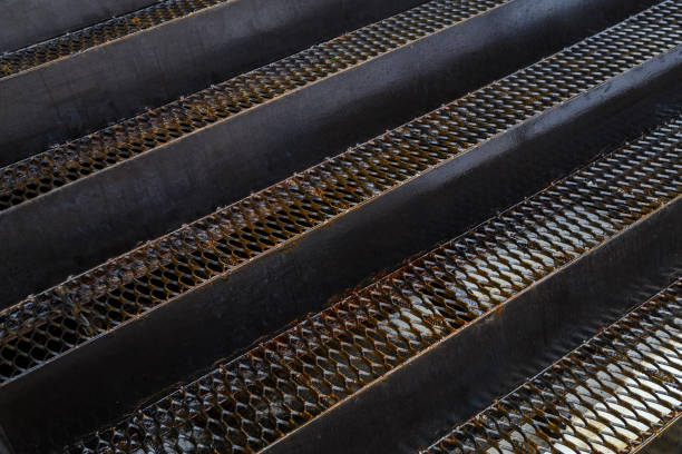 full frame background of wet iron grate stairs in diagonal perspective composition.