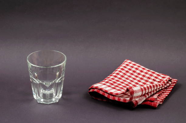 istock Empty glass and red checkered napkin on gray background. 1302089802