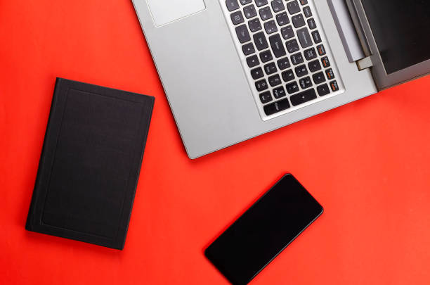 istock Hardcover book, phone, laptop on a red background. 1302089832