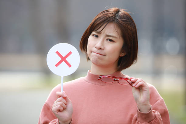 istock Woman with glasses and x tag 1302094074