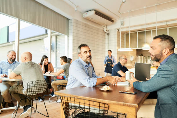 Doing business away from office Businessmen meeting in a coffee shop and discussing busy restaurant tables stock pictures, royalty-free photos & images