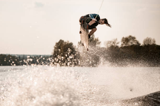 istock young healthy athletic guy makes incredible jump on wakeboard 1302098777
