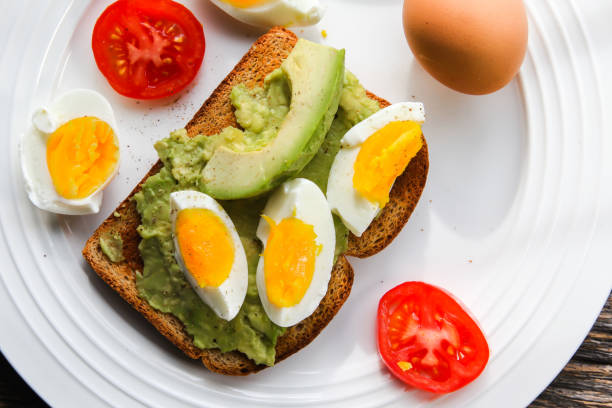 istock Toast with avocado, tomato slices and eggs on plate from above 1302099938