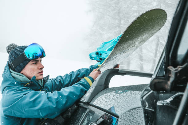 istock Young man taking snowboard from the car 1302101966