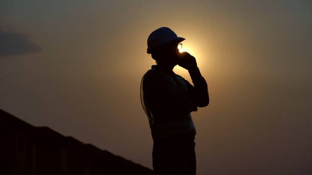 istock silhouette Civil engineer inspection building and calling on site 1302102263
