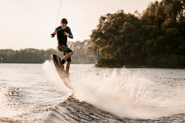 istock young male wakeboarder jumps with board on the splashing wave 1302102509