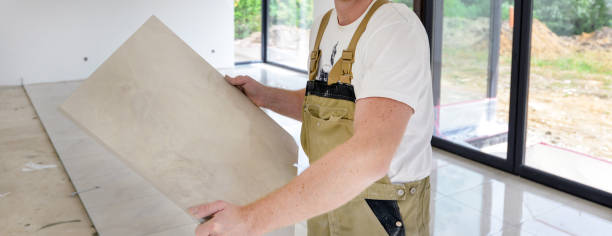 istock Craftsman in working clothes holding new cut ceramic tiles in his hands 1302104897