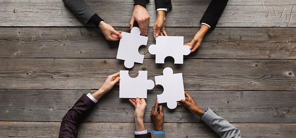 Business teamwork with white puzzle of four pieces cooperation unity concept