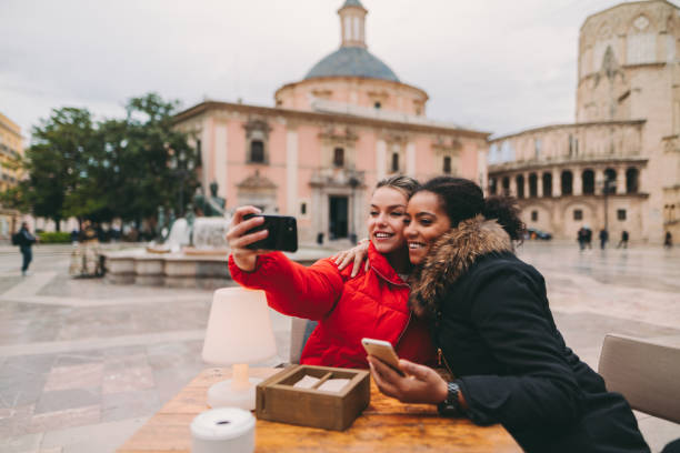 Friends visiting Valencia taking selfie at Plaza de la Virgen