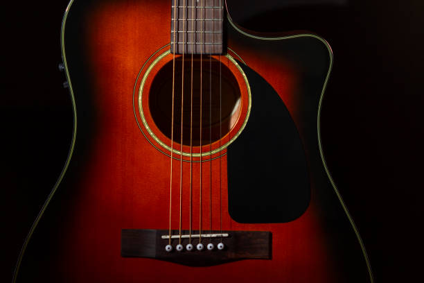 istock Acoustic guitar. Part of the case and strings on a black background. 1302110450