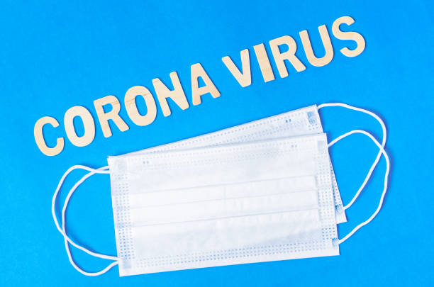 istock Blue disposable face mask with letters and text corona virus 1302110707