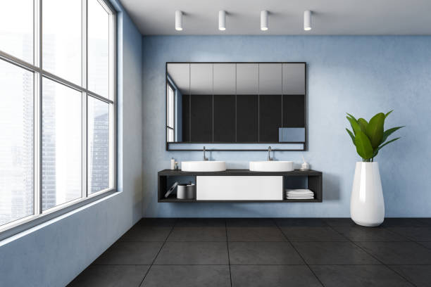 istock Blue and black bathroom, two sinks with mirror near window and plant 1302111806