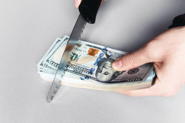 istock sawing money with a saw on a white background concept corruption 1302113335