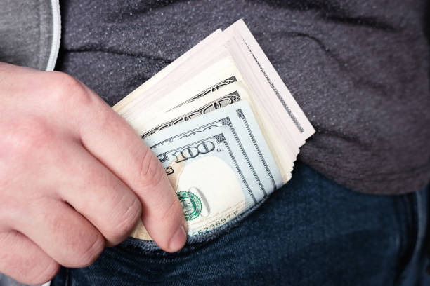 istock man pulls money out of his pocket close-up 1302113355