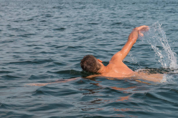 istock Young man swimming in the lake 1302115576