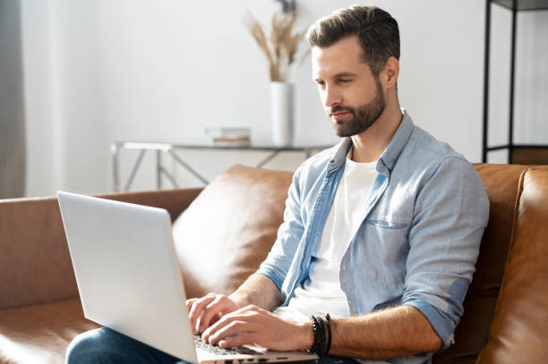 istock Handsome bearded guy wearing casual shirt using laptop 1302115975