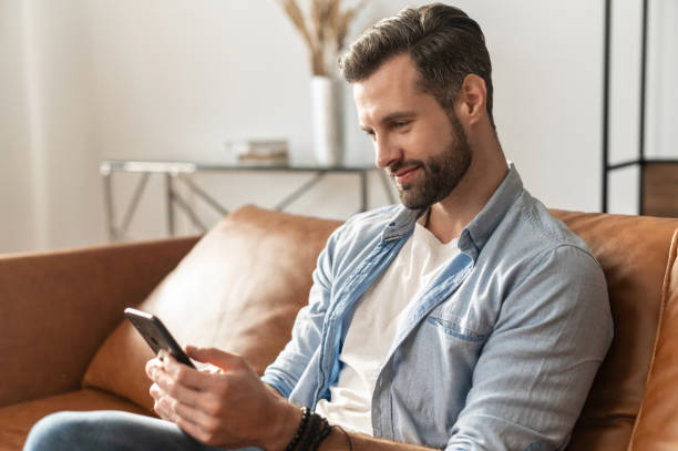 istock Handsome bearded guy wearing casual shirt using a phone 1302116030