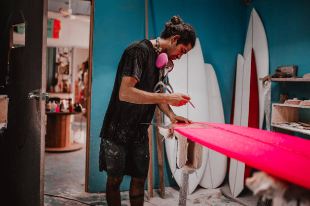 istock Man doing the final touches on the surfboard 1302118412