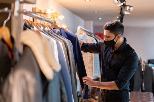 istock Young man organizing clothes in a warehouse 1302122228