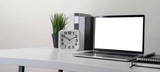 istock Modern contemporary workspace with blank screen laptop computer with office supplies and stationery on office desk on white background for copy space. Home office workplace concept. 1302123784