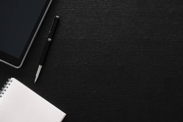 istock black office desk table with computer, tablet, mobile phone, and office supplies - table top view with copy space 1302123820