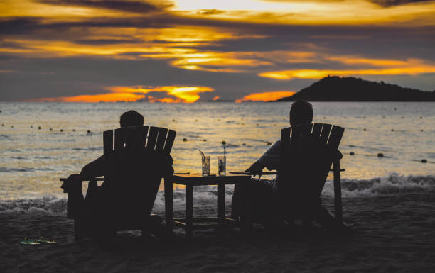 istock Silhouette couple relax chair on the beach. 1302127336